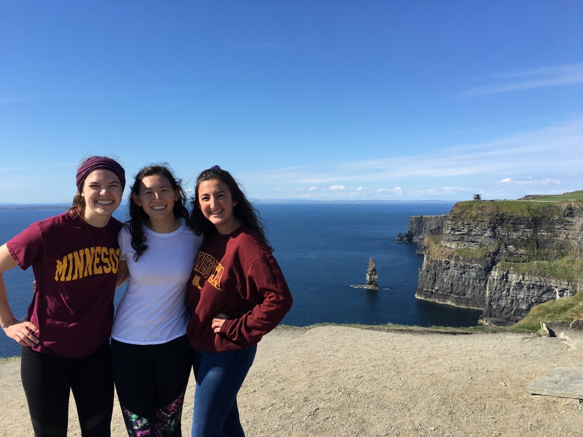 Three students standing in front of Cliffs of Moher