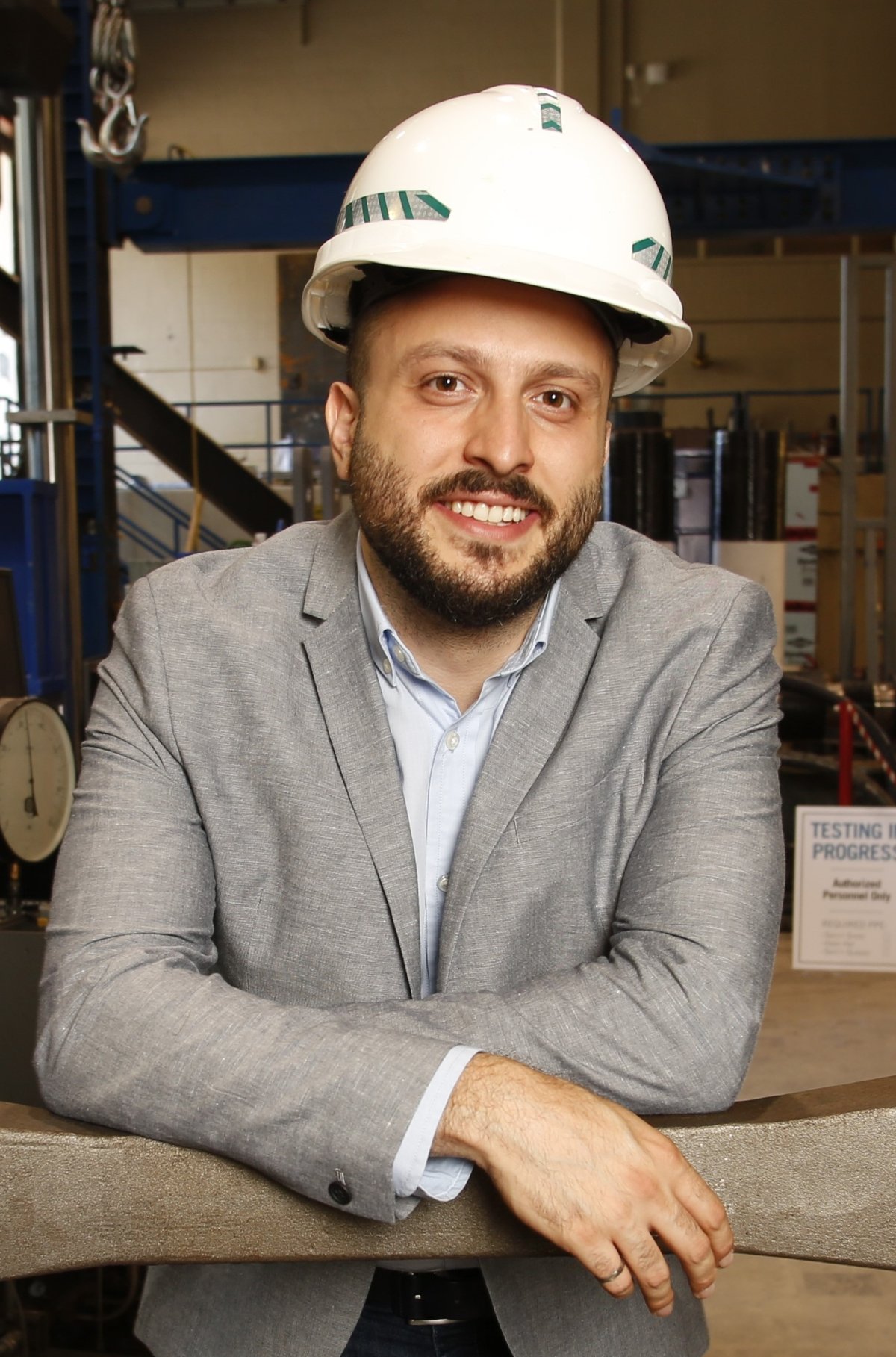 Pedram Mortazavi in a structures lab wearing a white hard hat