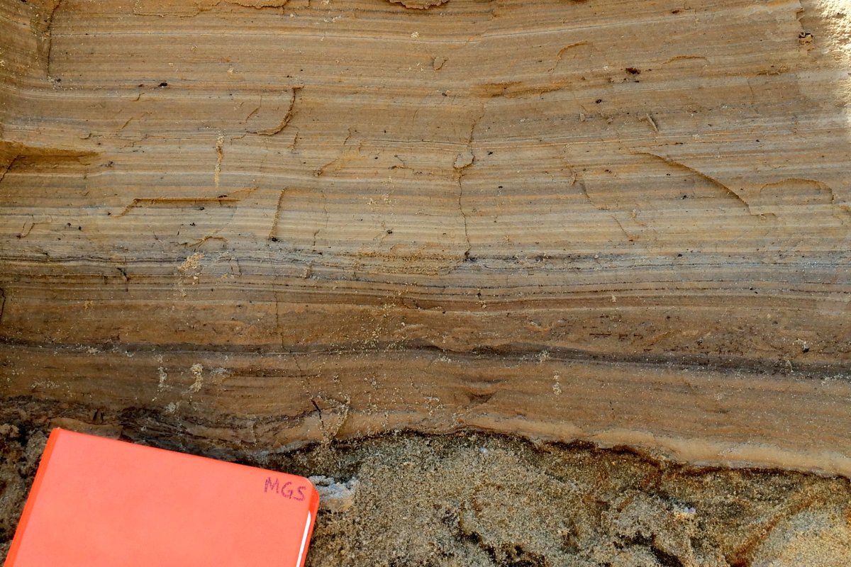 Finely-laminated lake (or lacustrine) sediment deposited over pebbly sand outwash sediment from an exposure in Kandiyohi County. The field notebook is placed at the contact between the two deposits.