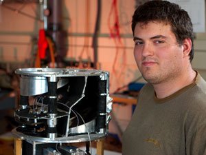 Physics graduate student, Kyle Zillic, with research equipment.