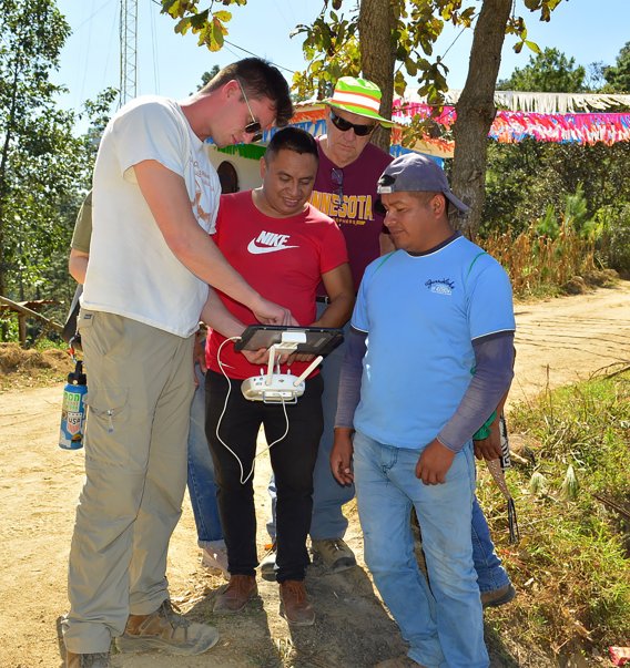 Drone Pilot Alex Behnke, Assistant Project Manager with Westwood, shows drone to Guatemalan partners