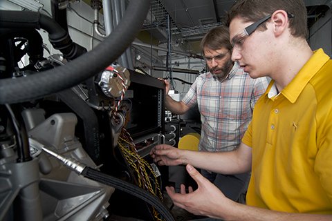 Professor and student working on an engine