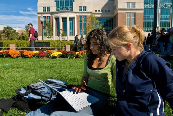 Students studying on the lawn near Nils Hasselmo Hall