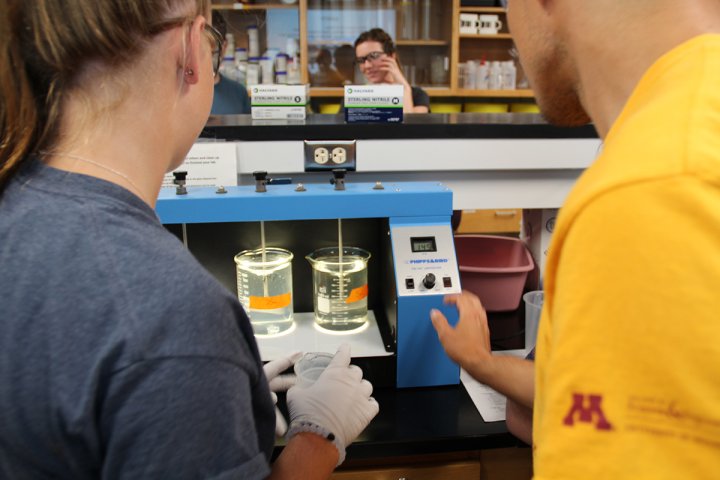 Two people in lab performing water floculation