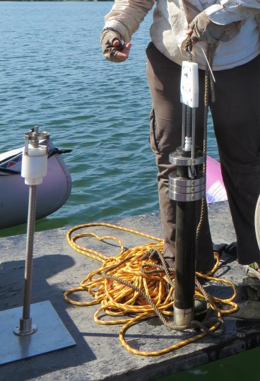 gravity coring device with tube full of mud and pile of rope on the right.  On the left is an extruding device for sediment.
