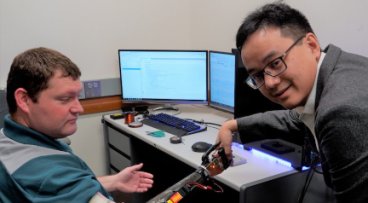 Professor Zhi Yang demonstrating a robotic arm