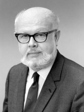 Black and white photo of bearded person with glasses