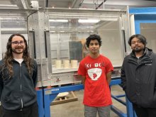 student Yash dagade stands with researchers in front of the wind tunnel he designed