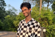 Apekshik Panigrahi poses outside in checkered shirt