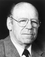 Black and white photo of person with glasses and suit