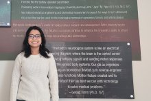 Renata Saha standing in front of a quote from Gerald Timm painted on a wall, called the Wall of Innovation