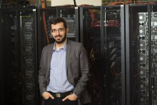 Turan Birol standing in front of supercomputers.