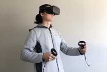 A man wearing a virtual reality headset and holding controllers in his hands.