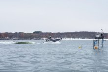Wakesurf boat on the lake with measurement equipment in the water