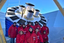 Members of the BICEP collaboration in front of the new BICEP Array Telescope at the South Pole.