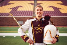 Rudin on football field smiling with drum major apparel