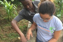student works with community member in Tanzania