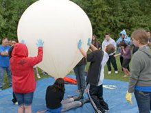 students launching weather balloons equipped with sensors, cameras, and GPS units