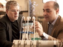 Larry Wackett and Alptekin Aksan look at set up of experiment in lab