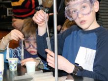 two children with goggles on conducting an activity