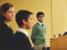 formally dressed student listens to classmates talk