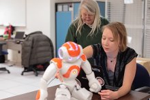 Two women researchers with a robot.