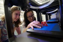 students looking at 3D printed block M
