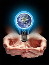 Hands holding earth in a light bulb