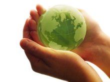 hands holding a green globe of earth