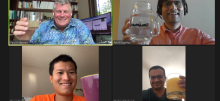 Photo of team of four people on Zoom smiling and celebrating with drinks