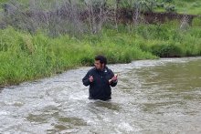 CSE earth sciences Ph.D. student Jabari Jones waist deep in a stream