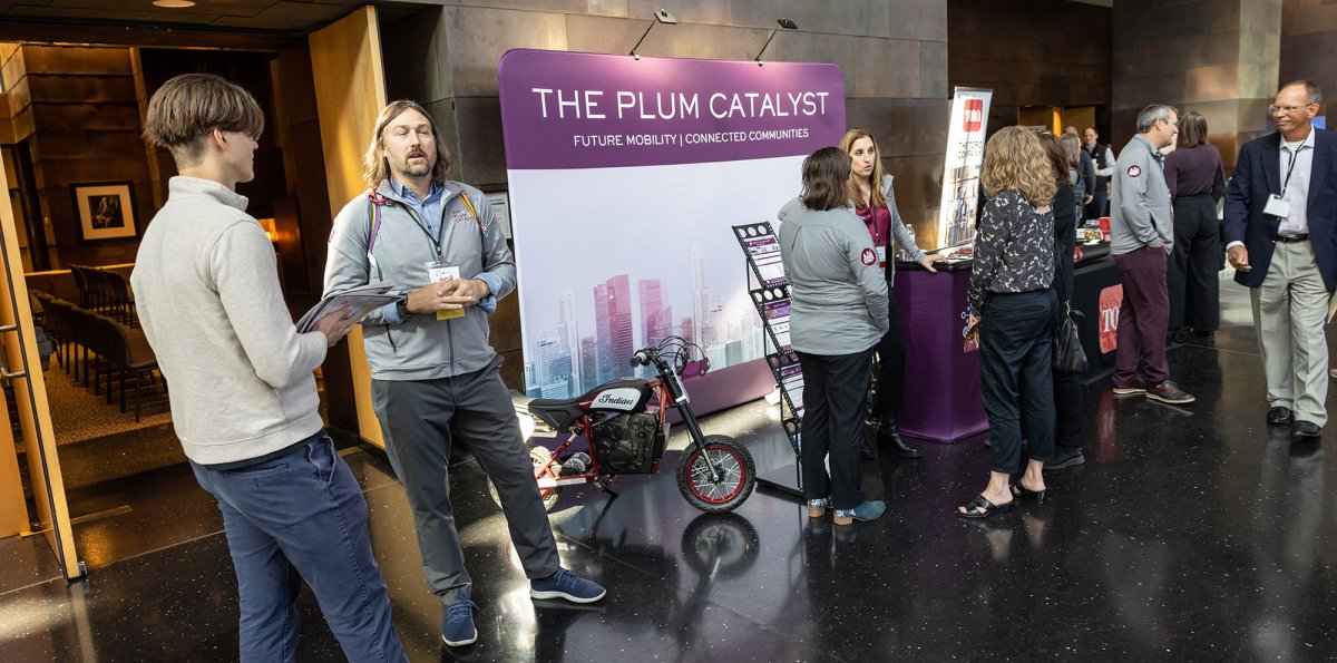 People standing around the Plum Catalyst table.