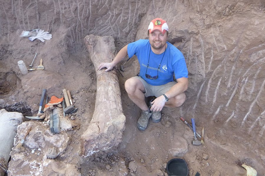Professor Makovicky in quarry in Argentina with large dinosaur bone