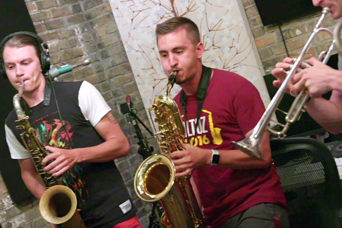 Two saxophone players in a recording studio.