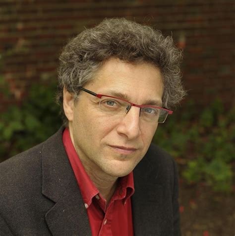 Man with dark curly hair and glasses