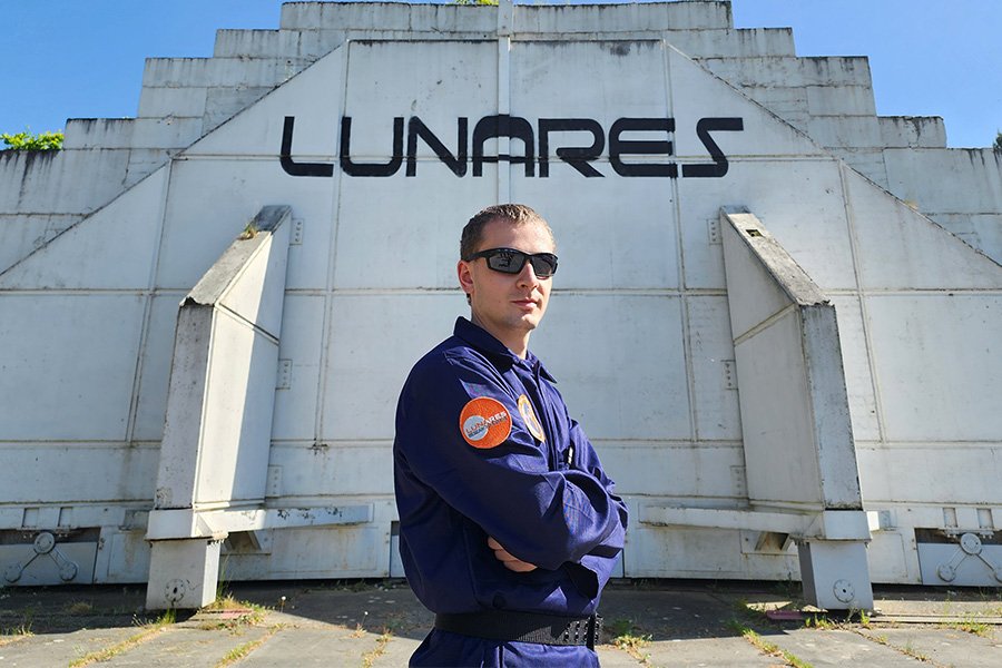 Graduate student Donovan Magney posing in front of the building at a LunAres Analog Astronaut Mission.