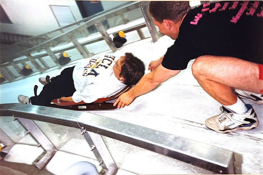 Two people at the start of a luge track.