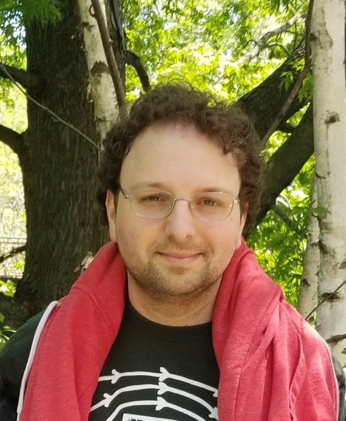 Professor Mikhail Kats standing outdoors in a graphic black T shirt