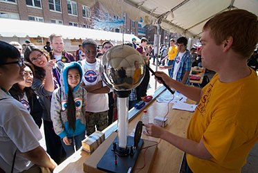 Chris Nolting demonstrates a Van de Graaff generator for middle schoolers at an outreach event.