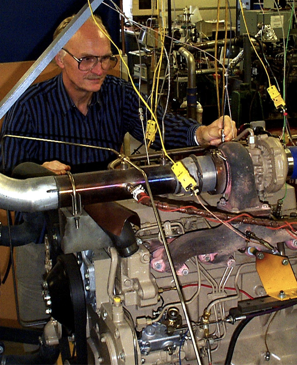 man wearing glasses works on engine