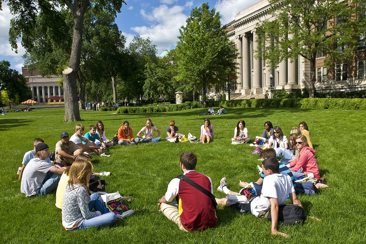 Students sitting in circle outside in a circle during orientation