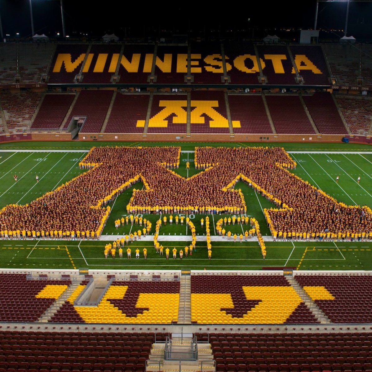 People forming on the football field in the shape of a UMN "M" and "2019"
