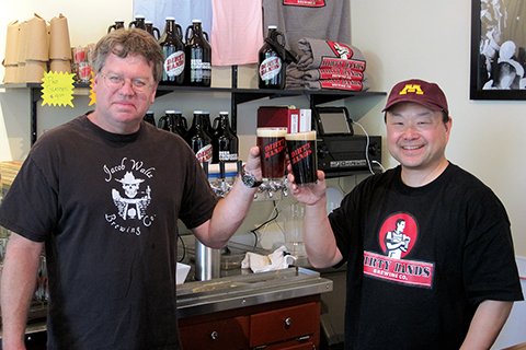 Dirty Hands brewers Phil Chou and Grant Merrill holding up glasses of beer