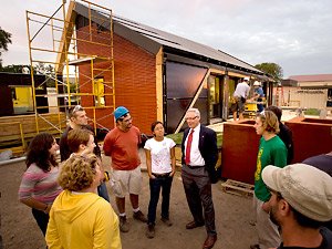 University of Minnesota President Robert Bruininks visits with students at the solar house they are building