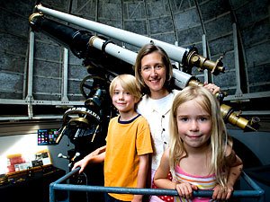Kristen McQuinn and kids posing by telescope