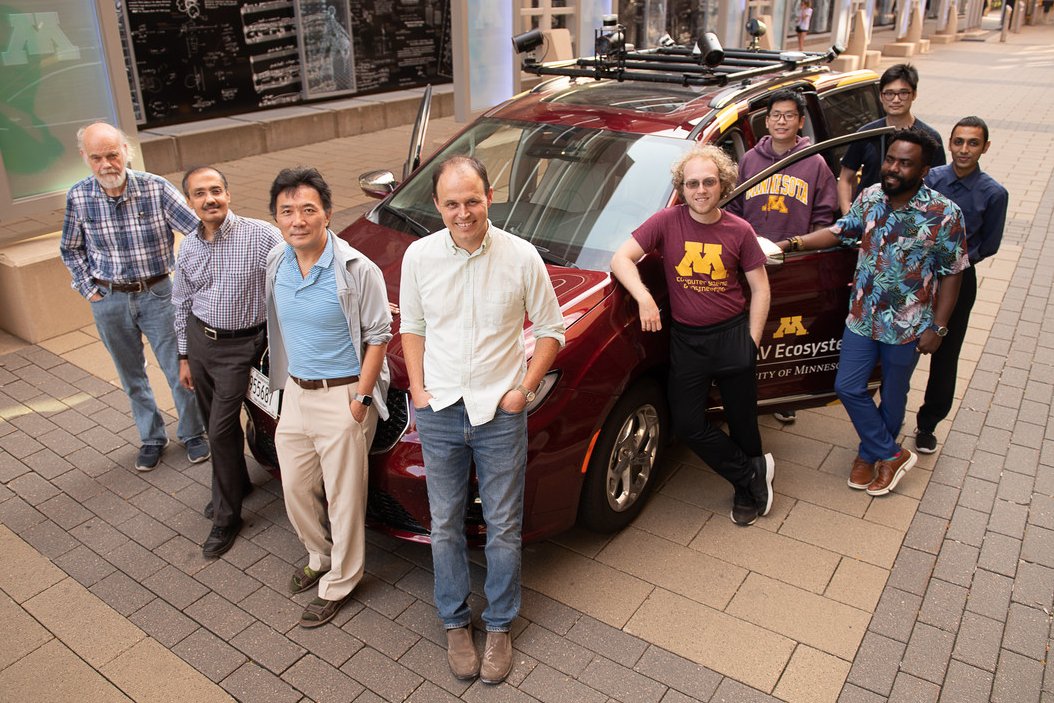 Jeff Calder and team standing next to an autonomous vehicle