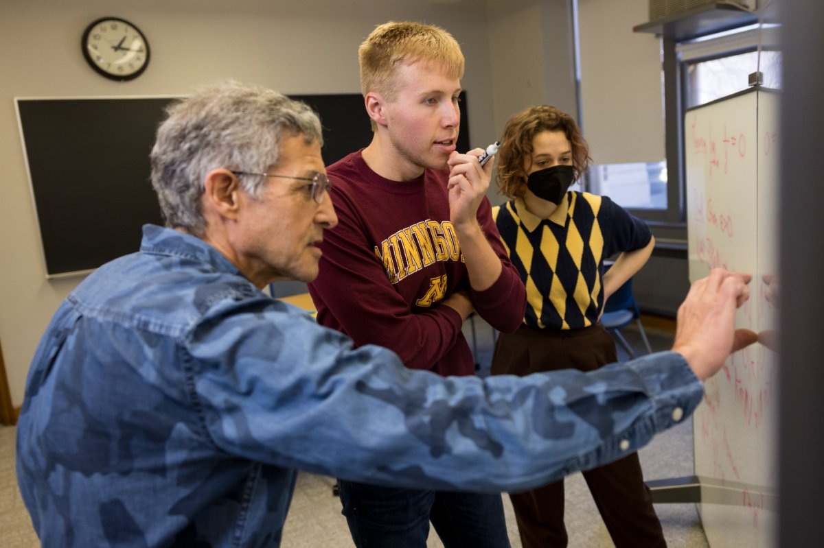 Professor teaching students at whiteboard