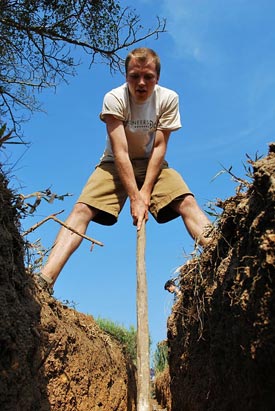 Student standing over a trench